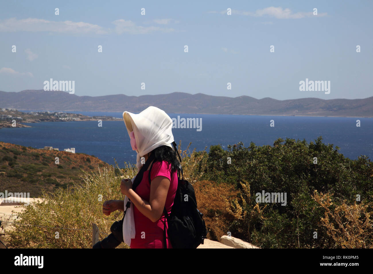 Attica Grèce Cap Sounion touriste avec écharpe enroulée autour de chapeau sur un jour de vent par le Temple de Poséidon Banque D'Images