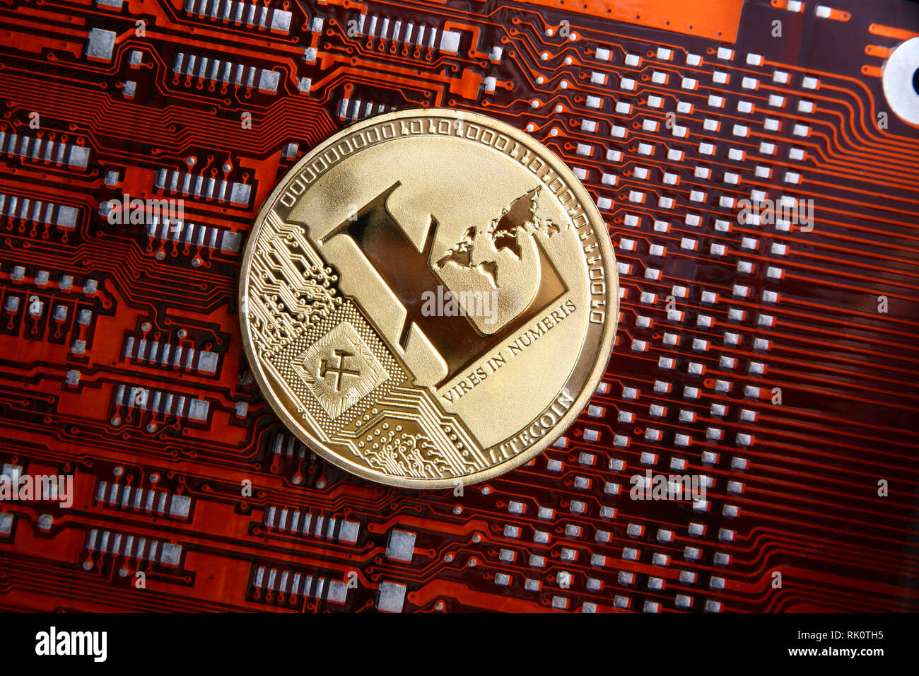 Litecoin monnaie d'or sur une orange ou rouge & noir circuit souple de l'ordinateur. Banque D'Images