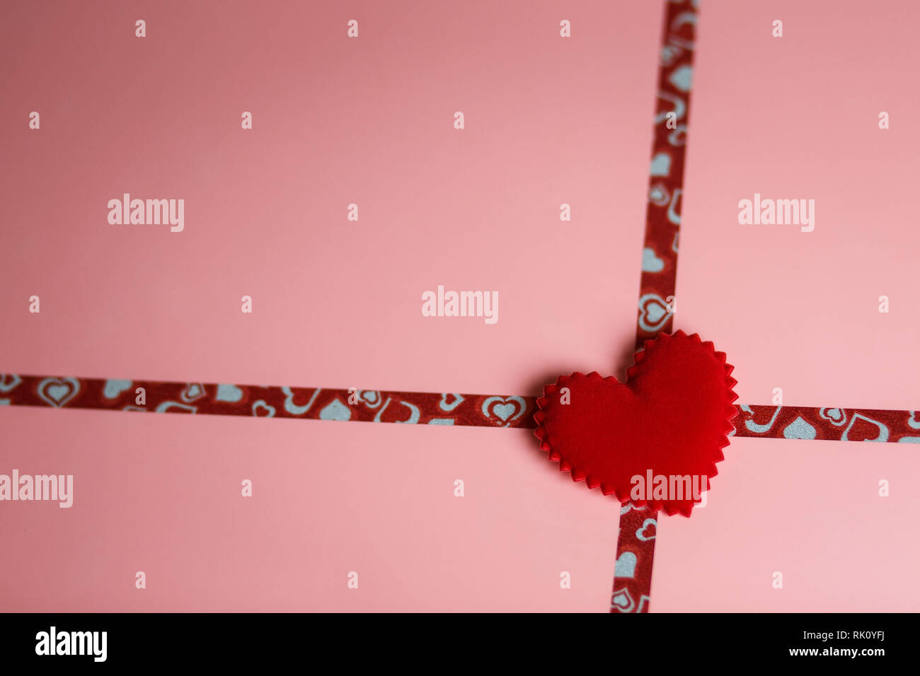 Un cadeau pour la Saint Valentin ou un mariage. L'emballage rose avec des rubans et de velours rouge coeur avec copie espace in soft focus Banque D'Images