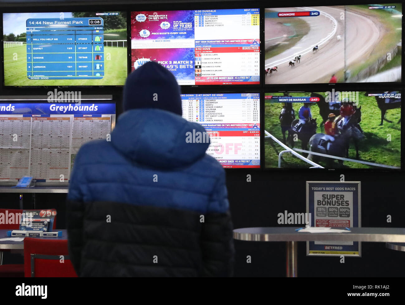 Les parieurs de courses de regarder autour de l'Europe sur les écrans de télévision, à un magasin de Betfred à Nottingham. Banque D'Images