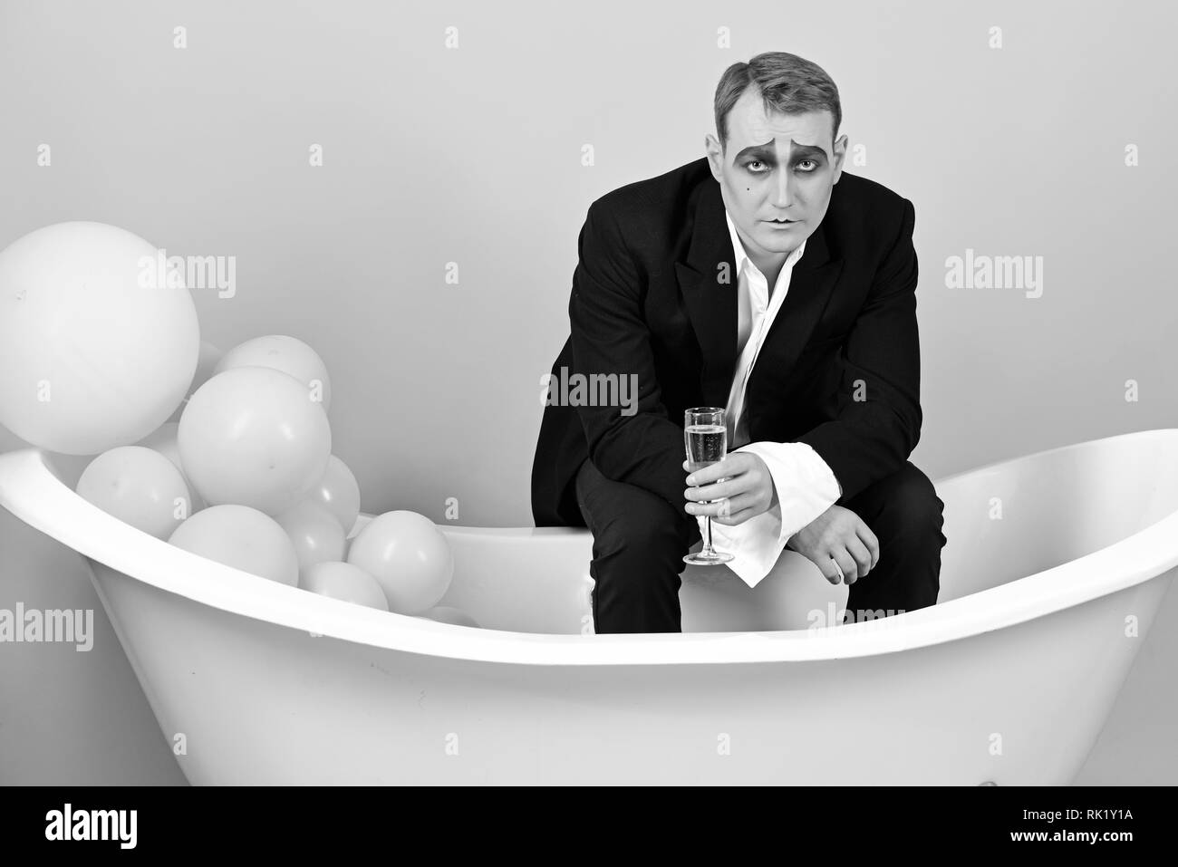 La boisson du moment. Célébrer l'homme mime avec champagne dans la baignoire. Acteur comédien théâtre profiter fête célébrant. Acteur Mime a celebration party Banque D'Images