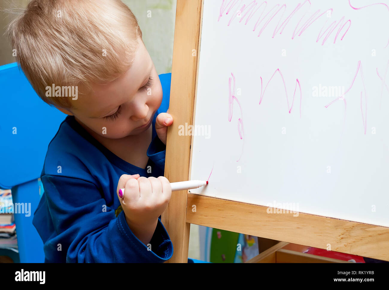 Le Petit Garçon Apprend à Dessiner Sur Un Tableau Blanc