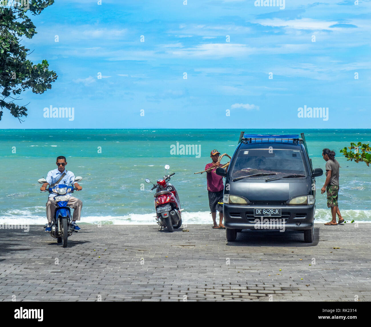 Trois hommes à la baie de Jimbaran, Bali Indonésie. Banque D'Images