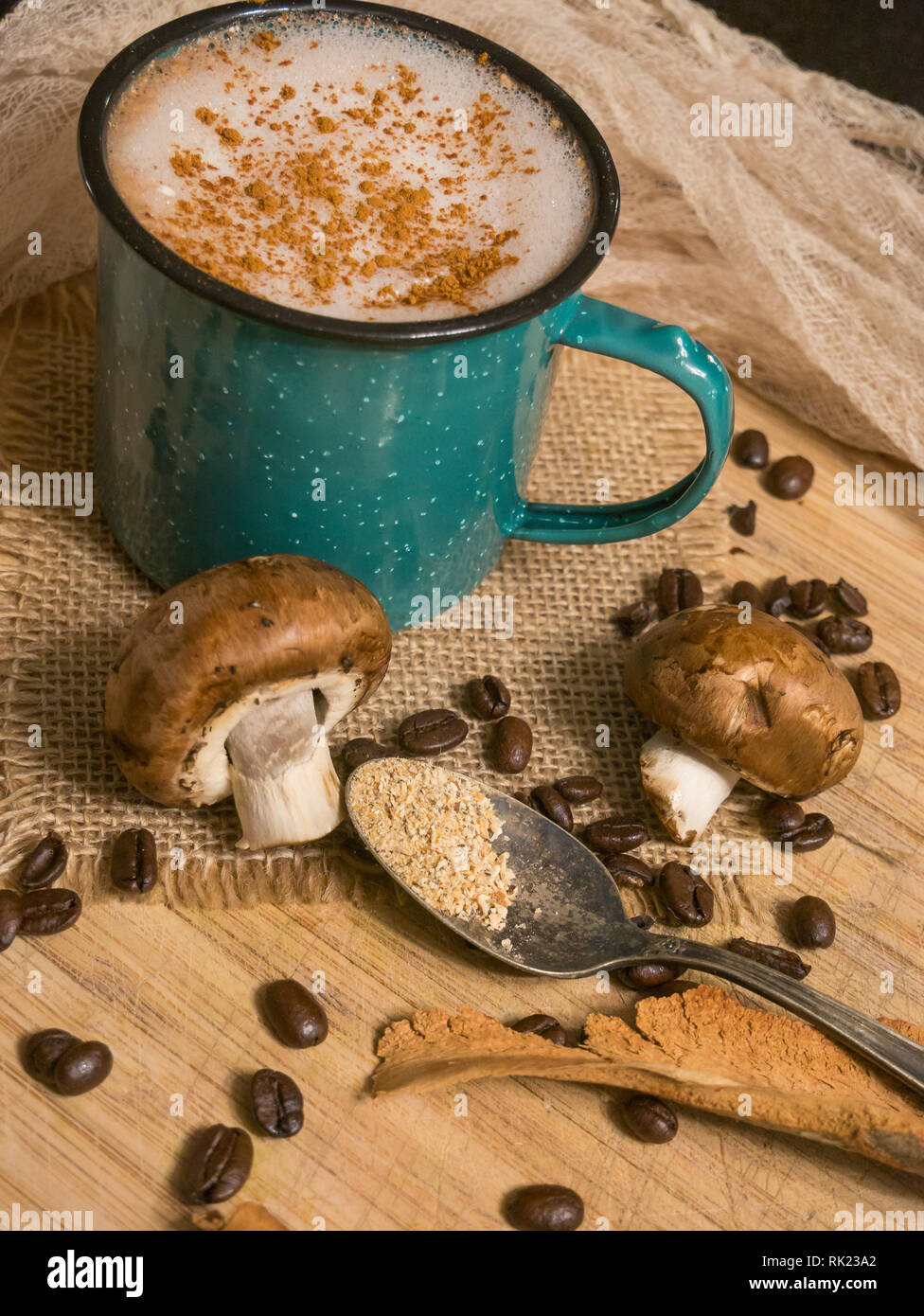Latte de champignons sur une planche en bois avec une cuillère et les grains de café dispersés aux champignons Banque D'Images