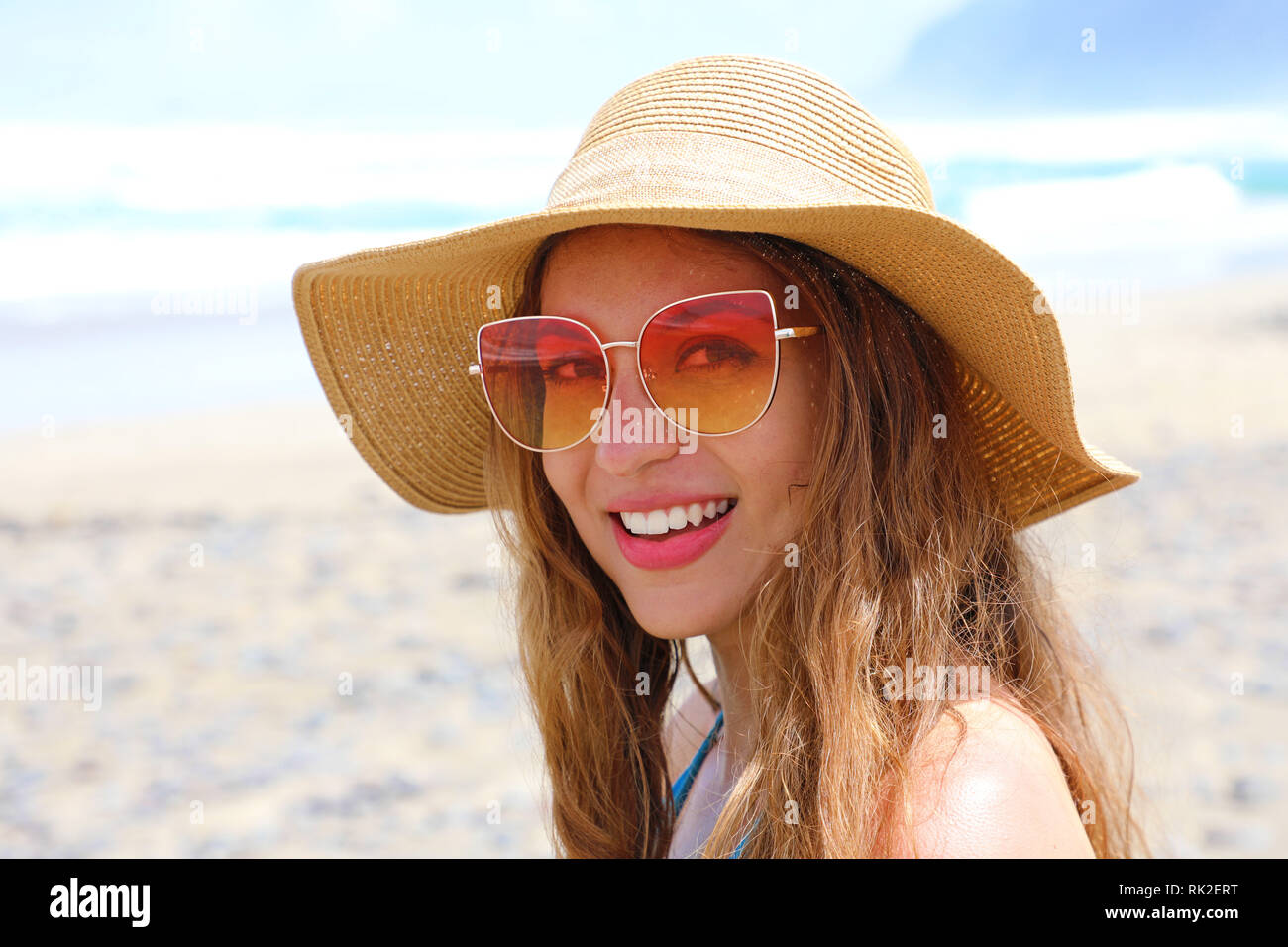 Souriante jeune femme avec chapeau et lunettes de soleil sur la plage en  regardant la caméra. Happy girl à Îles Canaries, Espagne Photo Stock - Alamy