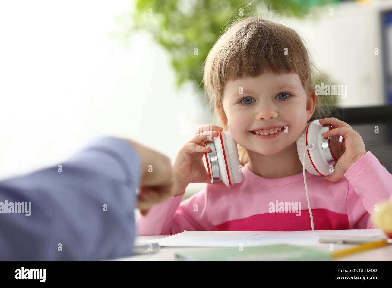 L'enfant assis au casque satisfait Banque D'Images