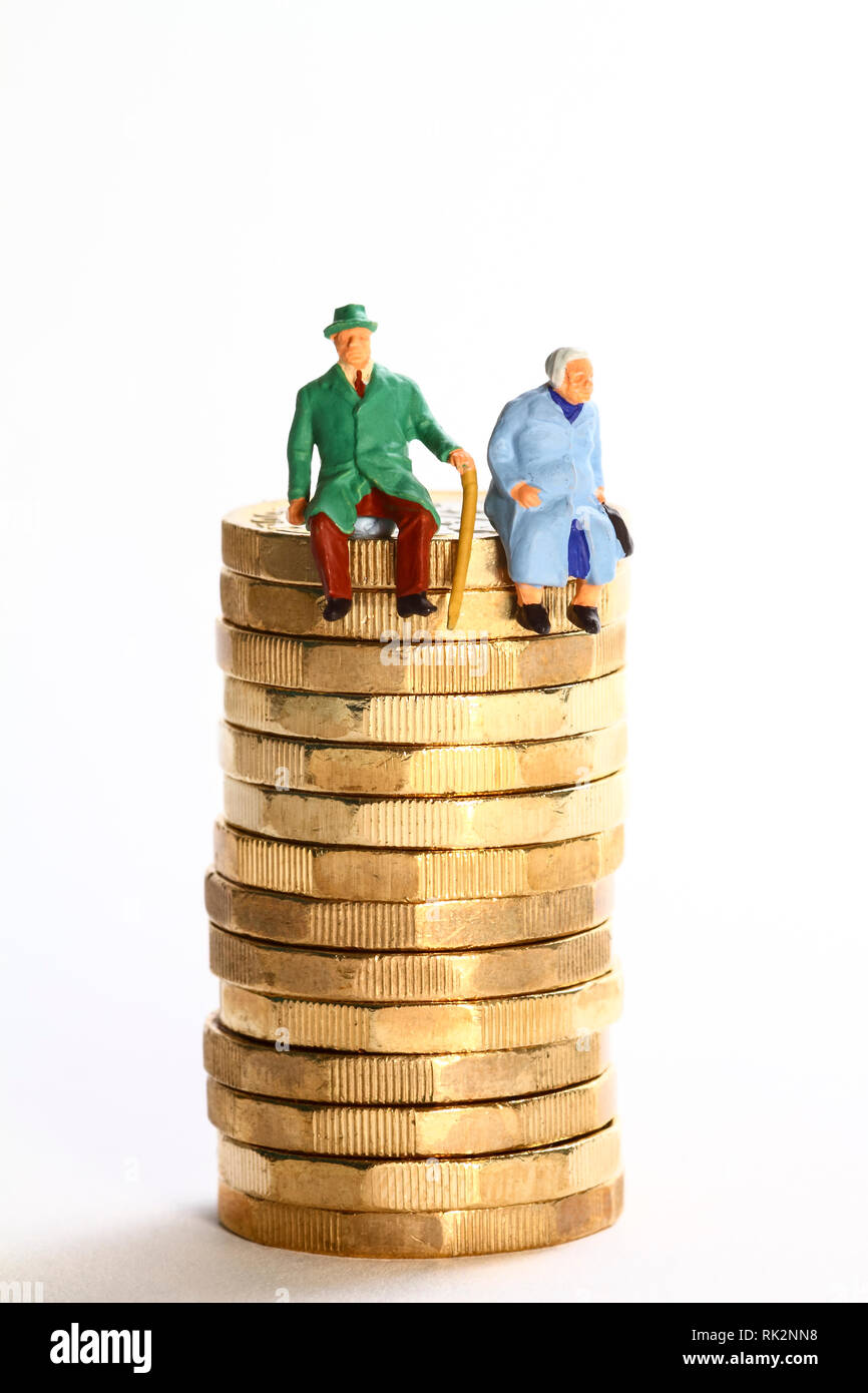L'image conceptuelle diorama d'une figure miniature à la retraite couple assis sur une pile de pièces en livres Banque D'Images