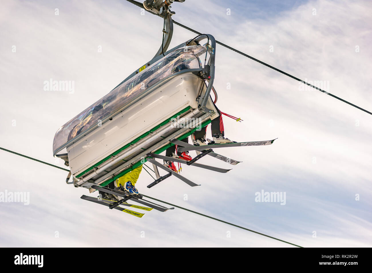 Quatre skieurs sur un télésiège contre le ciel bleu, vu d'en bas, de la pente de ski. Station de ski de Schladming Dachstein, Styrie, Autriche Banque D'Images