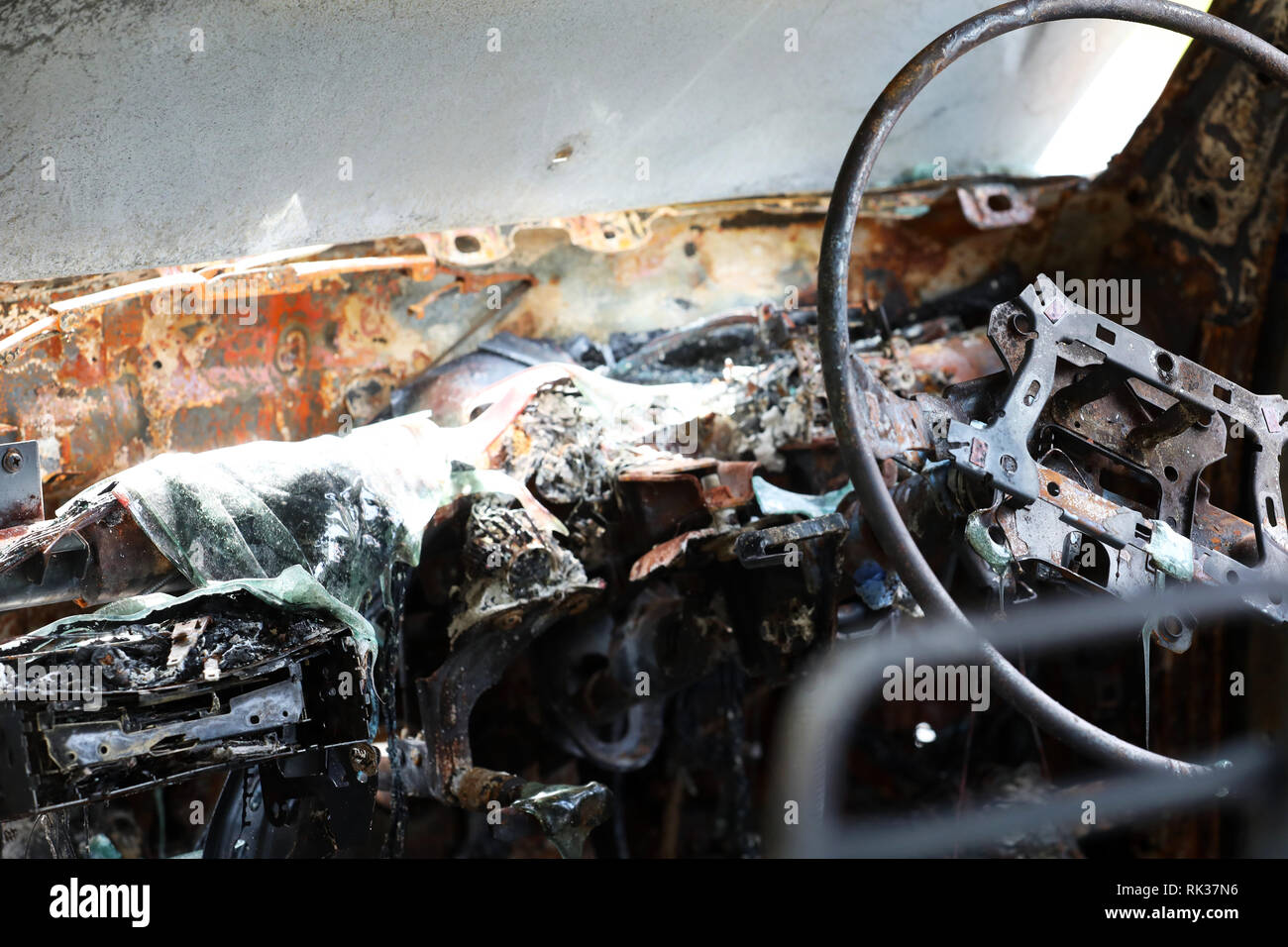 À l'intérieur de Burnt Out épave de voiture volée. Scène de crime de droit de l'intérieur du véhicule ruiné par le feu ou d'incendie. plastique fondu et de métal et volant Banque D'Images