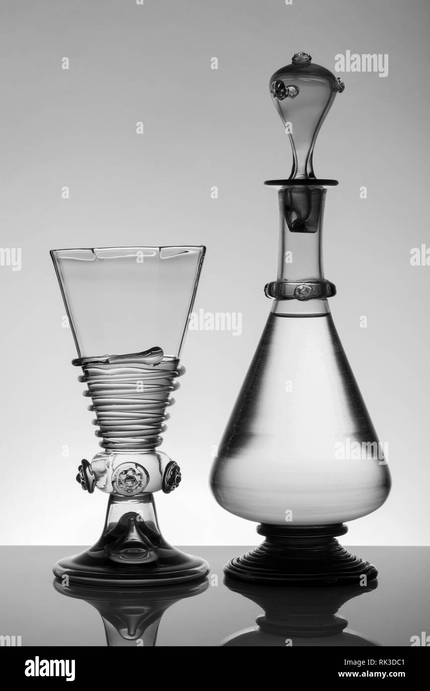 L'âge moyen rummer wine glass et la bouteille sur le fond blanc. Le noir et blanc, monochrome photo. Banque D'Images