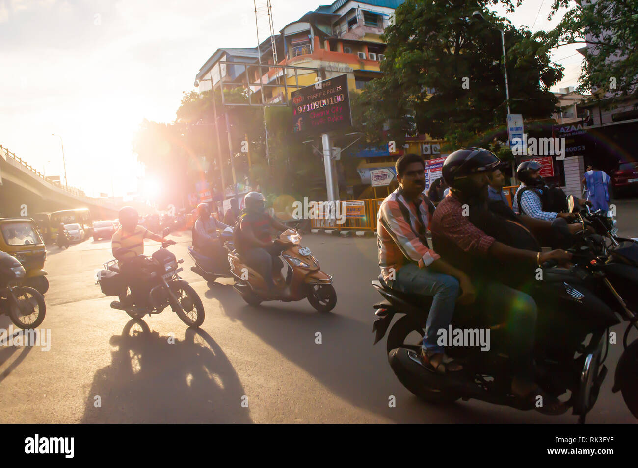 Soleil de l'après-midi Cours d'eau par les usagers sur leur moto sin Chennai, Inde du Sud, en tant que chef des travailleurs à la maison du travail Banque D'Images