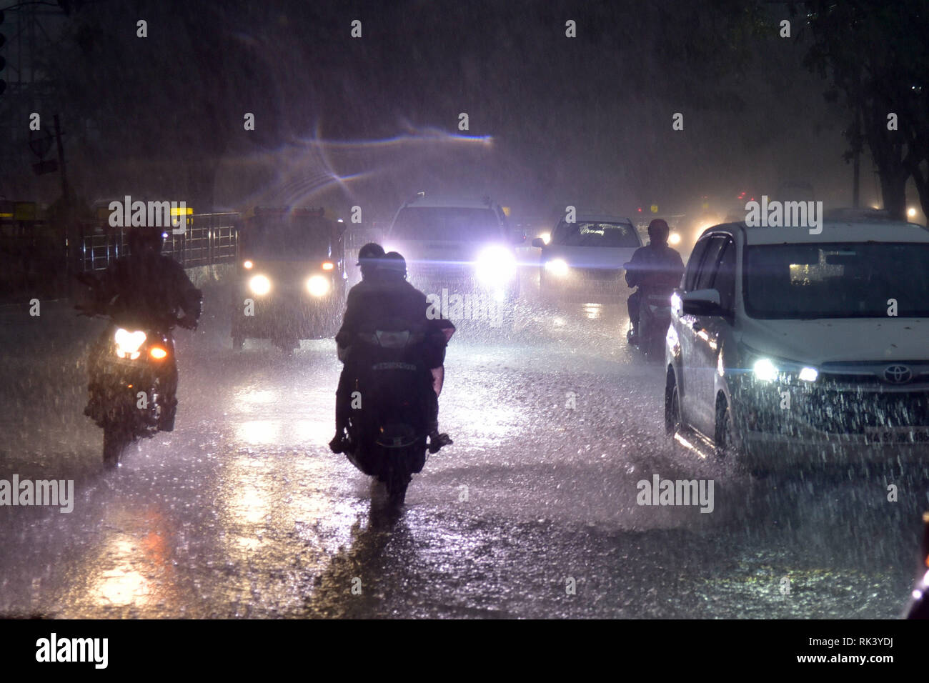 Bangalore, Inde. Feb 9, 2019. Véhicules péniblement leur chemin à travers les rues inondées à Bangalore, Inde, le 9 février 2019. Les gens de la ville de Bangalore a été témoin de la première pluie de 2019 le samedi. Credit : Stringer/Xinhua/Alamy Live News Banque D'Images