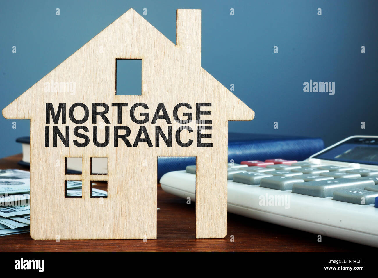 Concept d'assurance hypothécaire. Maison en bois, de l'argent et Calculatrice. Banque D'Images