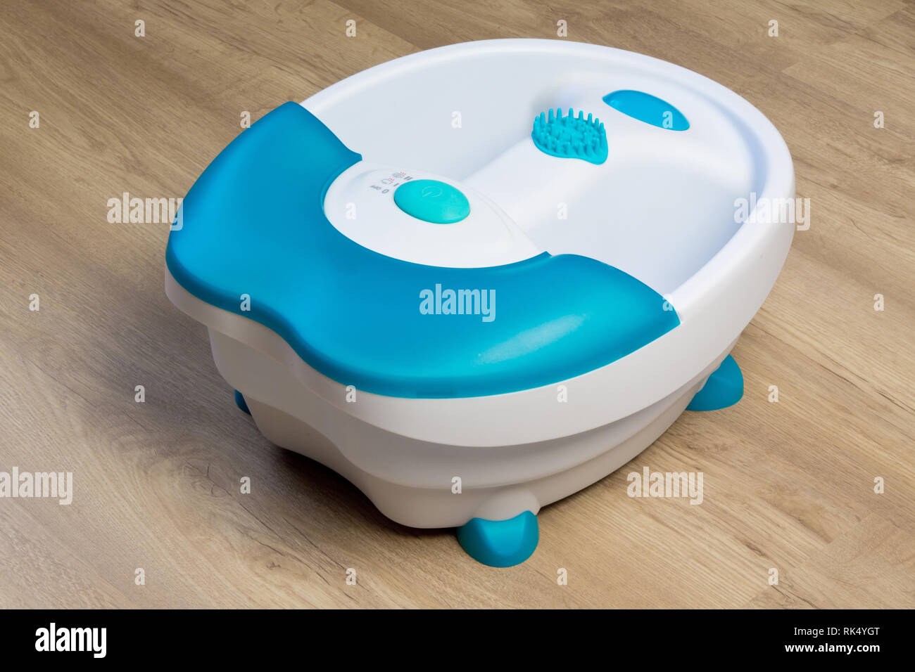 Pieds dans un tamis vibrant massage des pieds. Baignoire de massage électrique. Bain de pied avant d'une pédicure Banque D'Images