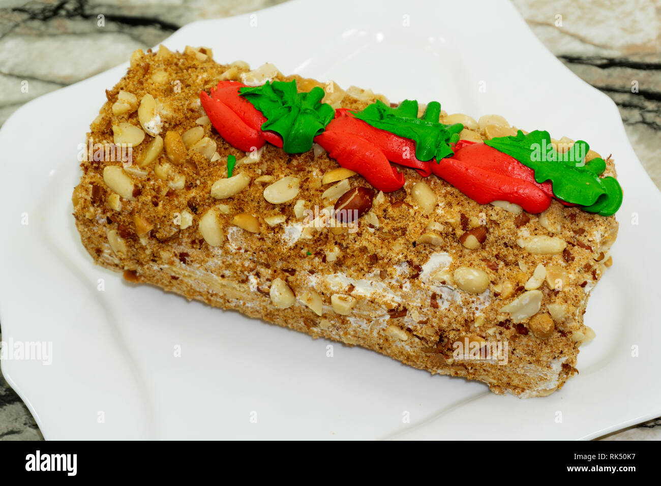 Gâteau à la crème beurre rouleau et sur plaque de bois blanc sur fond de bois . Banque D'Images