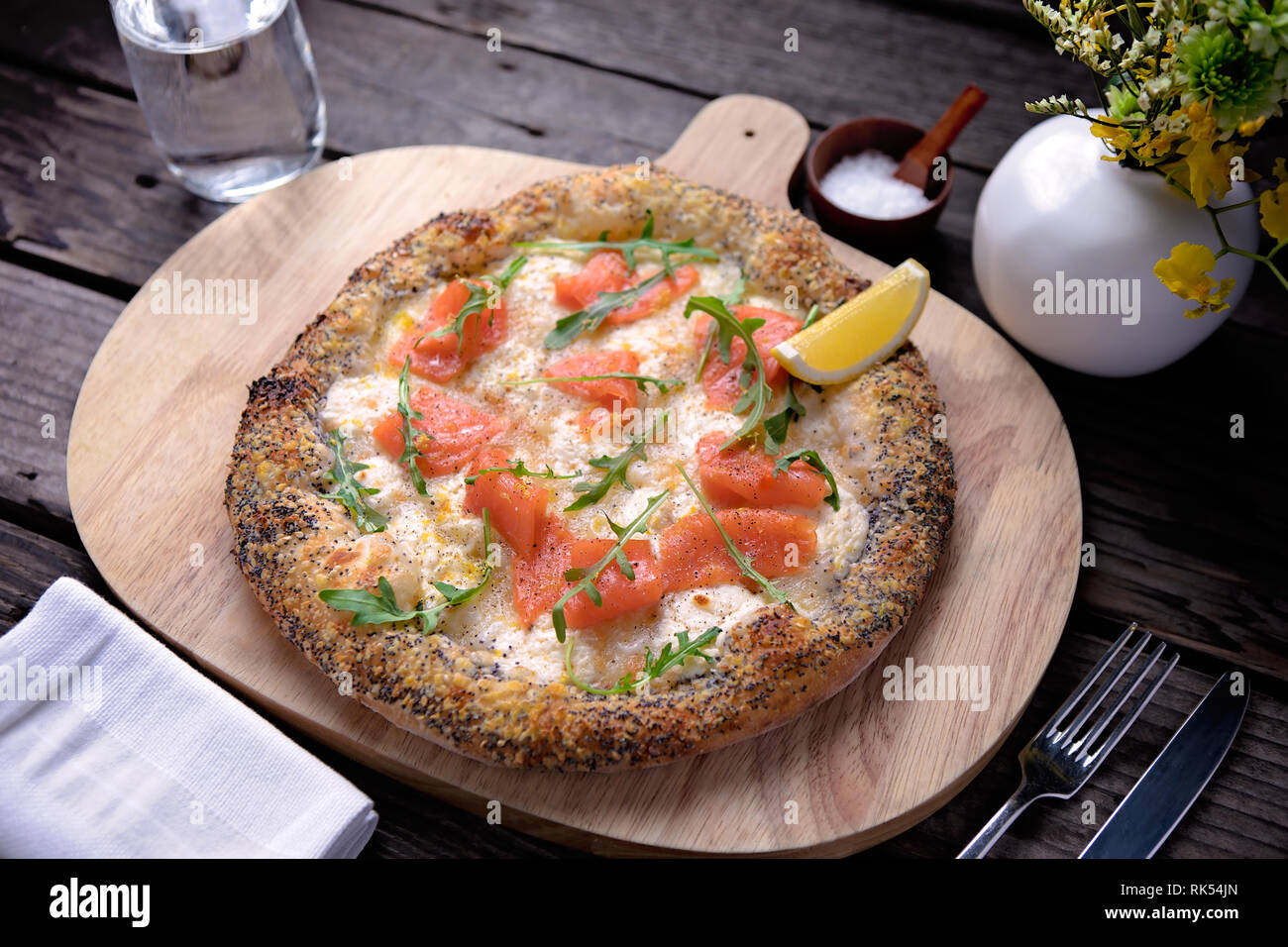 Pizza au saumon délicieux servi sur planche de bois Banque D'Images