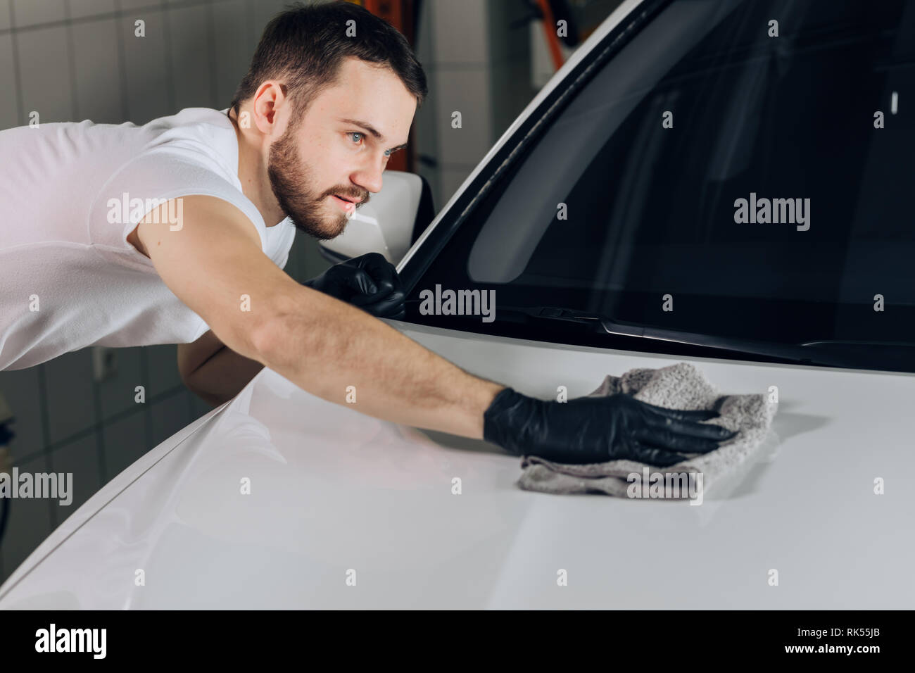 Le personnel est le nettoyage de la voiture, la photo en gros. Guy est le nettoyage de l'extérieur d'un véhicule. Banque D'Images