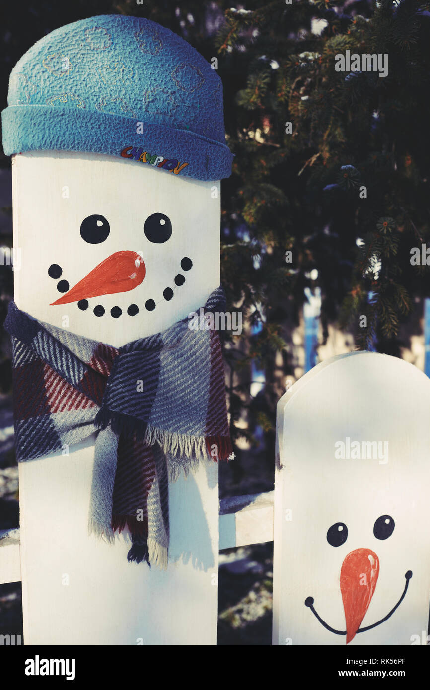 Le SNOWMAN peint sur une clôture, vêtu d'un chapeau de l'enfant Banque D'Images