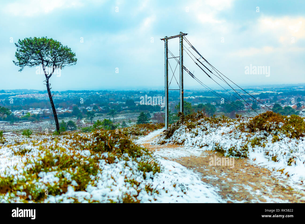 Photographie de paysage pris sur la réserve naturelle de Canford Heath en hiver avec vue sur la ville de Poole. Prises avec focus sélectif sur les poteaux électriques. Banque D'Images