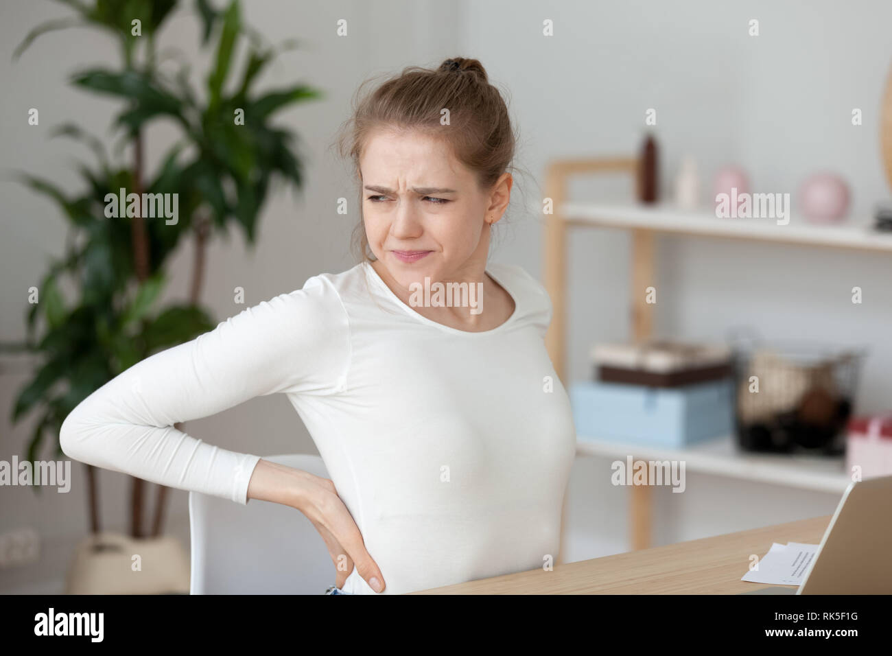 Sentiment fatigué girl back pain frotter les muscles après le travail sédentaire Banque D'Images