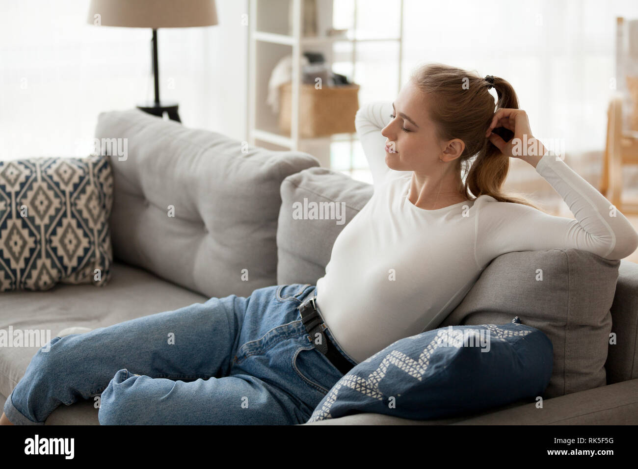 Jeune femme détendue reposant sur un canapé confortable respirer de l'air de détente Banque D'Images