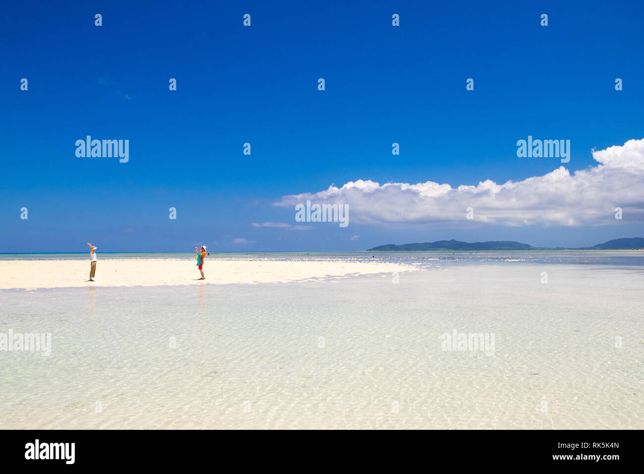 Un couple sur une pointe de sable blanc et eaux turquoise clair par. Kondoi Beach, Île Taketomi Island (Île Taketomi-jima), îles Yaeyama, Okinawa Prefecture, Japan. Banque D'Images