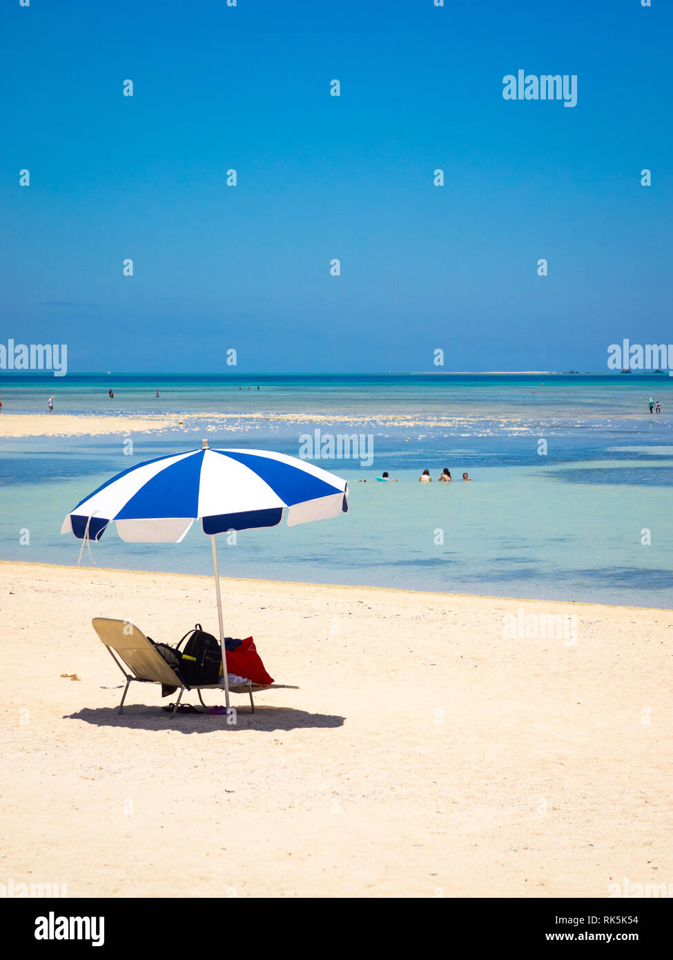 Les touristes et les parasols de plage bleu et blanc sur Kondoi Beach, Île Taketomi Island (Île Taketomi-jima), îles Yaeyama, Okinawa Prefecture, Japan. Banque D'Images
