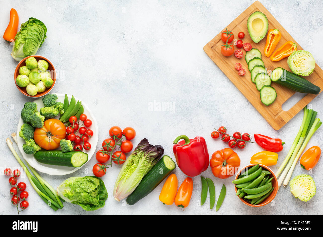 Matières premières fraîches concombres tomates ingrédients Salade de poivron brocoli laitue oignon pois sur le tableau blanc, vue du dessus, copiez l'espace, selective focus Banque D'Images