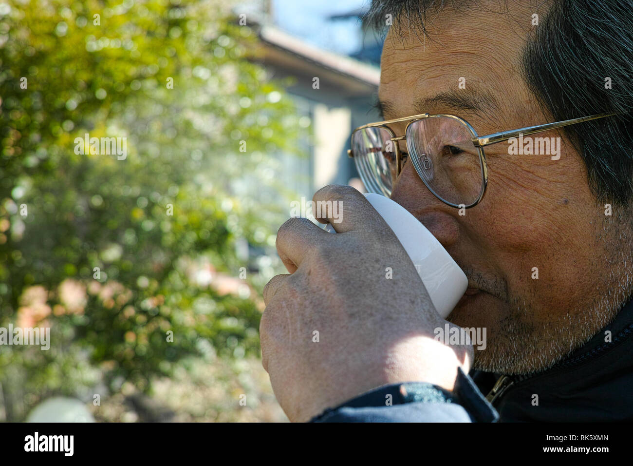 Un homme de boire une bonne tasse de thé japonais sur un matin froid Banque D'Images
