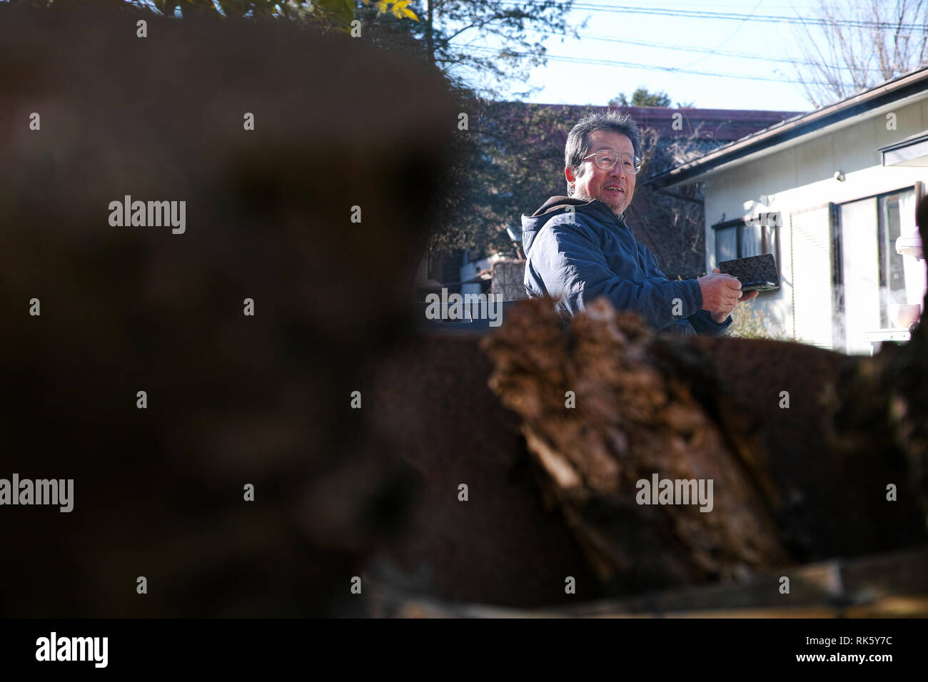 Un homme dans son jardin à la campagne la conversation tout en utilisant son téléphone Banque D'Images