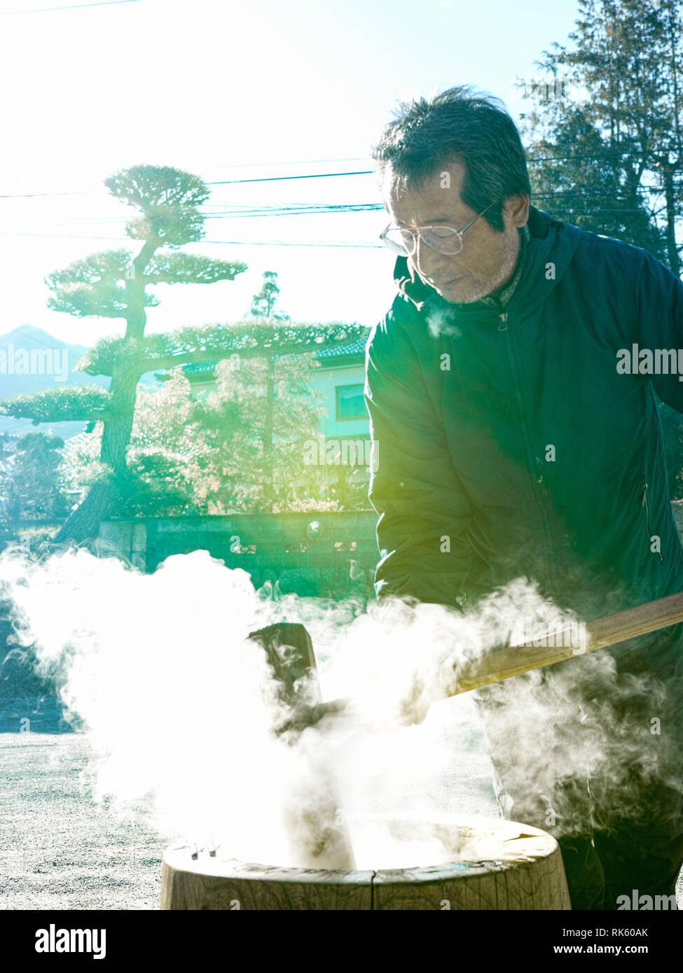Un homme plus âgé faisant mochi en hiver avec la vapeur chaude du riz. Banque D'Images