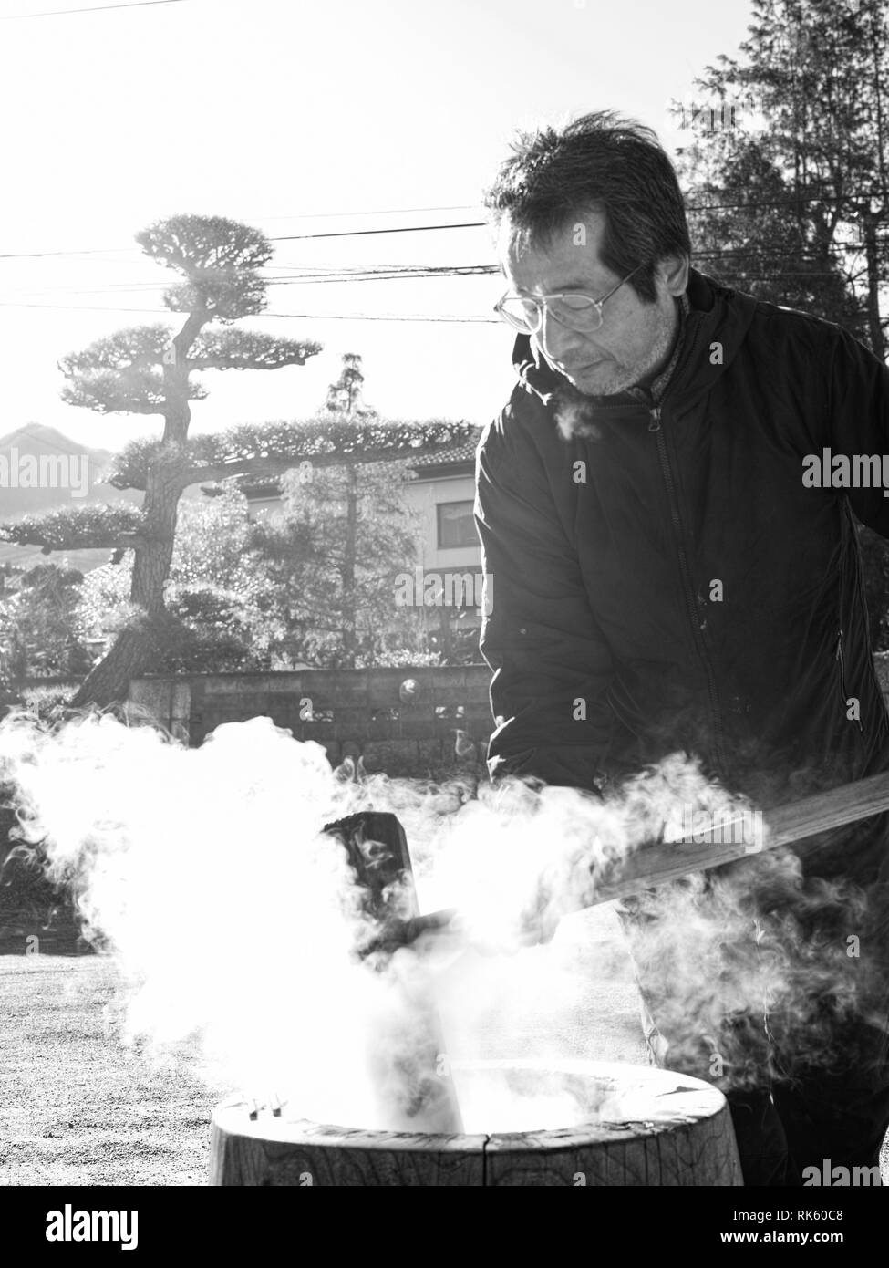 Un homme plus âgé faisant mochi en hiver avec la vapeur chaude du riz. Banque D'Images