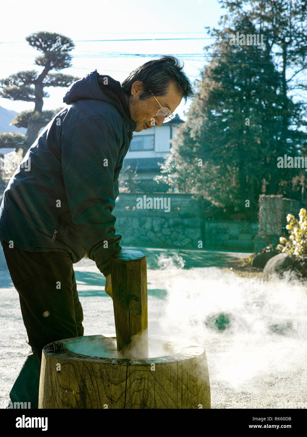 Un homme plus âgé faisant mochi en hiver avec la vapeur chaude du riz. Banque D'Images
