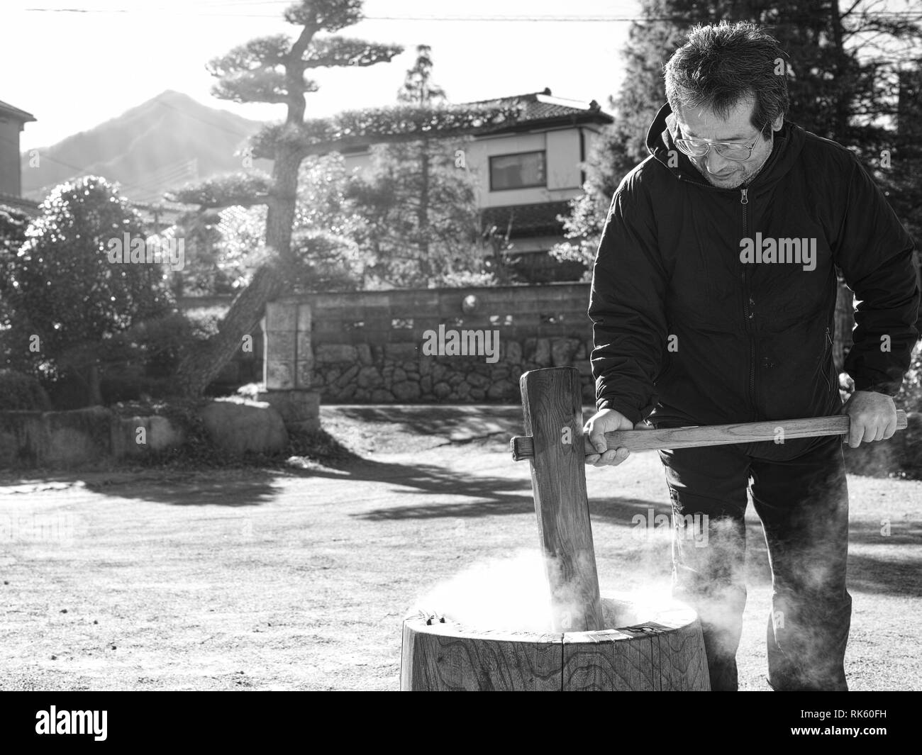 Un homme plus âgé faisant mochi en hiver avec la vapeur chaude du riz. Banque D'Images