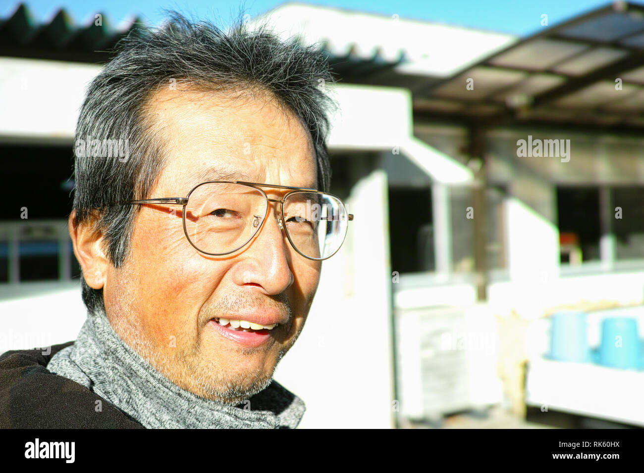 Un vieux paysan souriant à l'appareil photo avant de partir au travail Banque D'Images