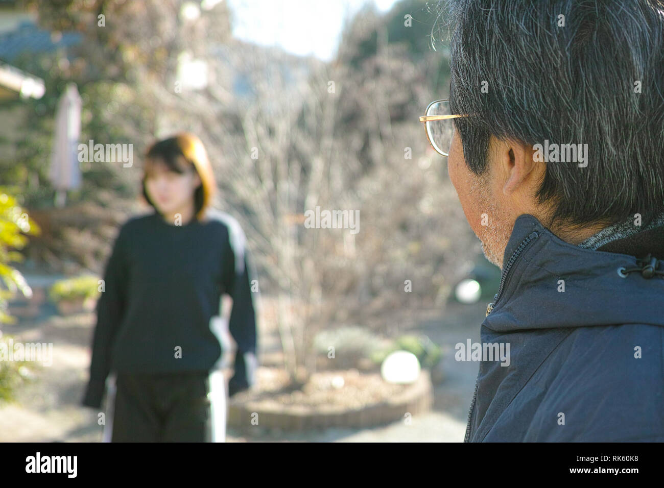 Un vieux père regardant sa fille floue au loin. Banque D'Images