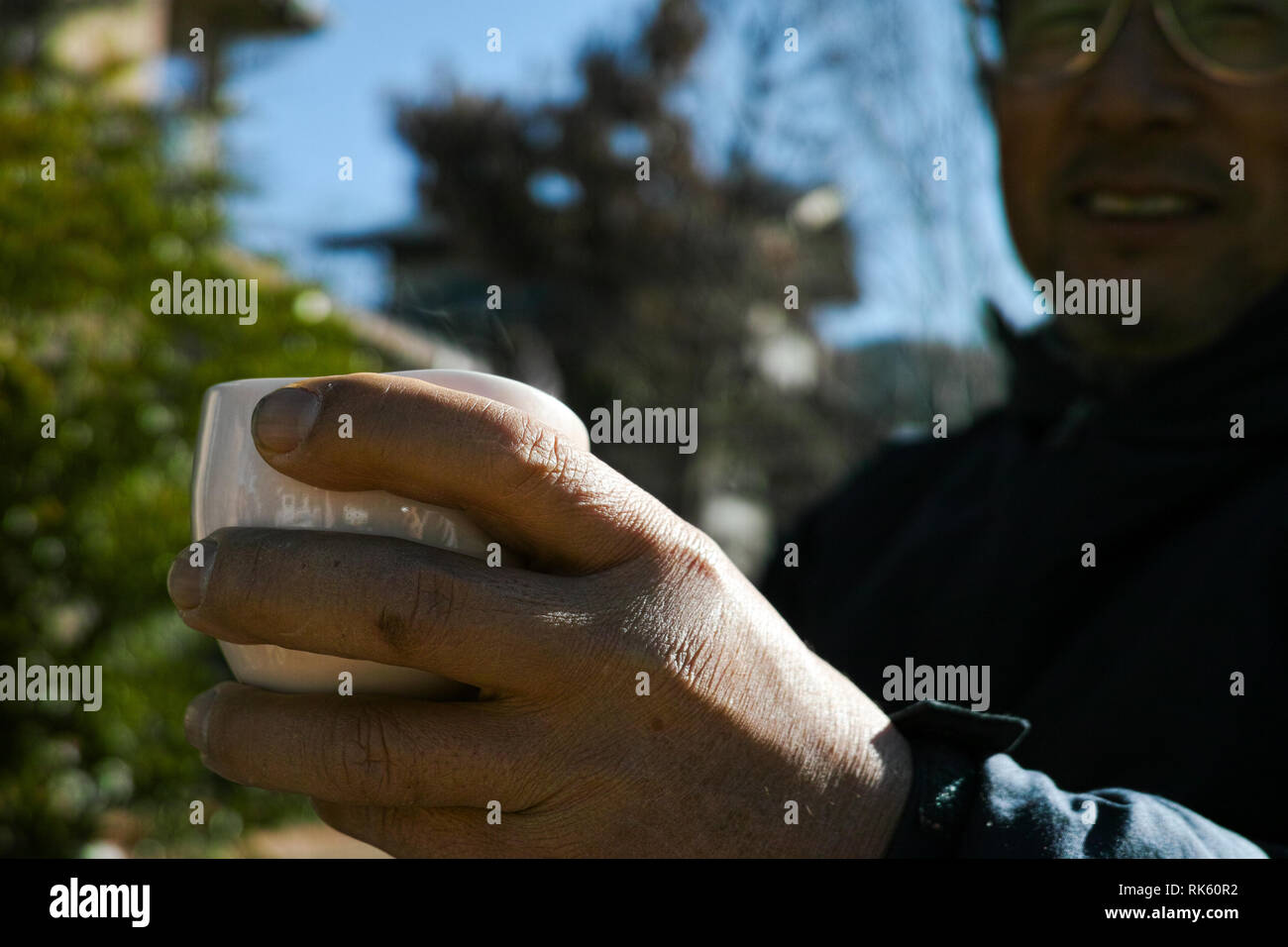 Un homme tenant une tasse de thé japonais sur un matin froid Banque D'Images