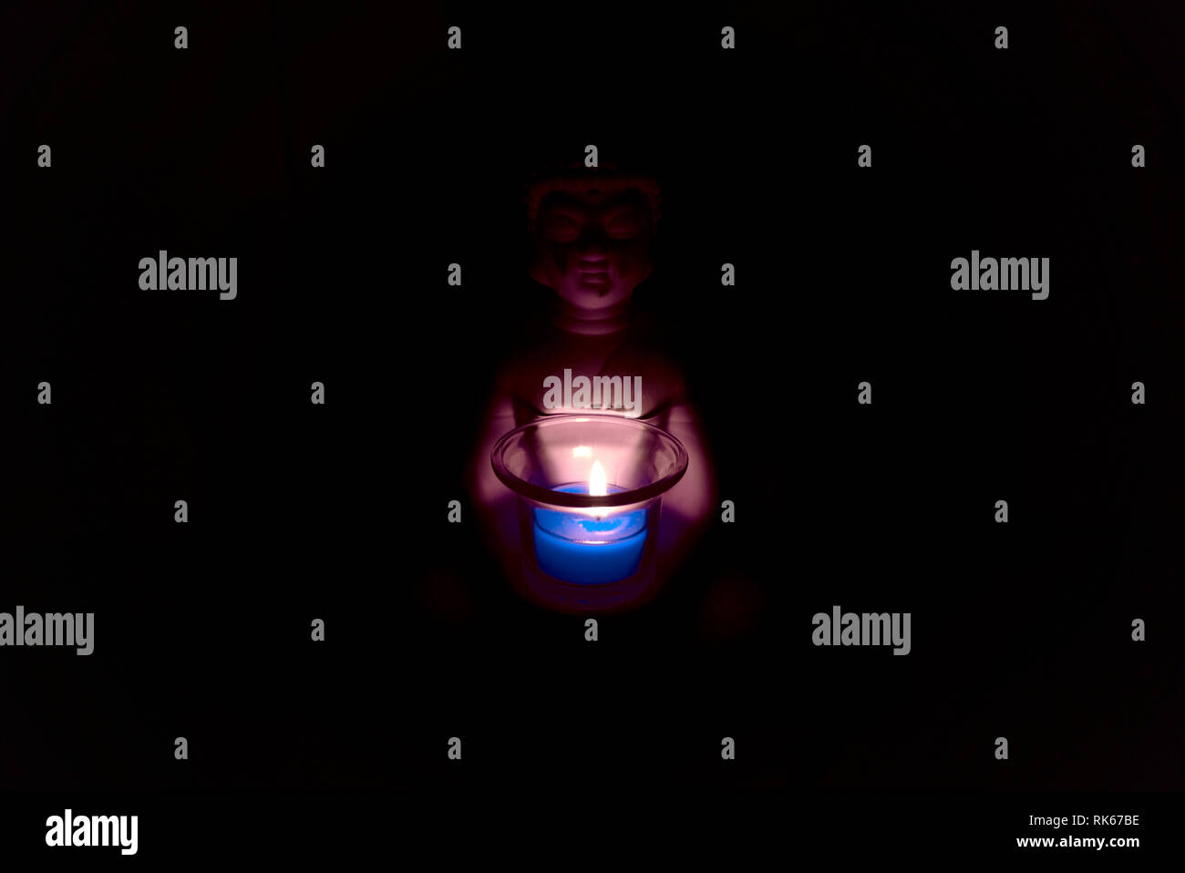 Bouddha tenant un verre avec une bougie peut en elle. environnement sombre et effrayant atmosphère spirituelle de la religion. Banque D'Images