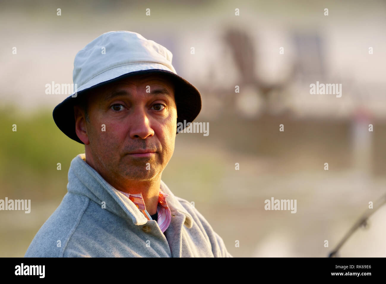 Portrait, portrait d'un pêcheur de race blanche, 50 ans, au bord du lac avec brouillard, tôt le matin juste avant le lever du soleil. Banque D'Images