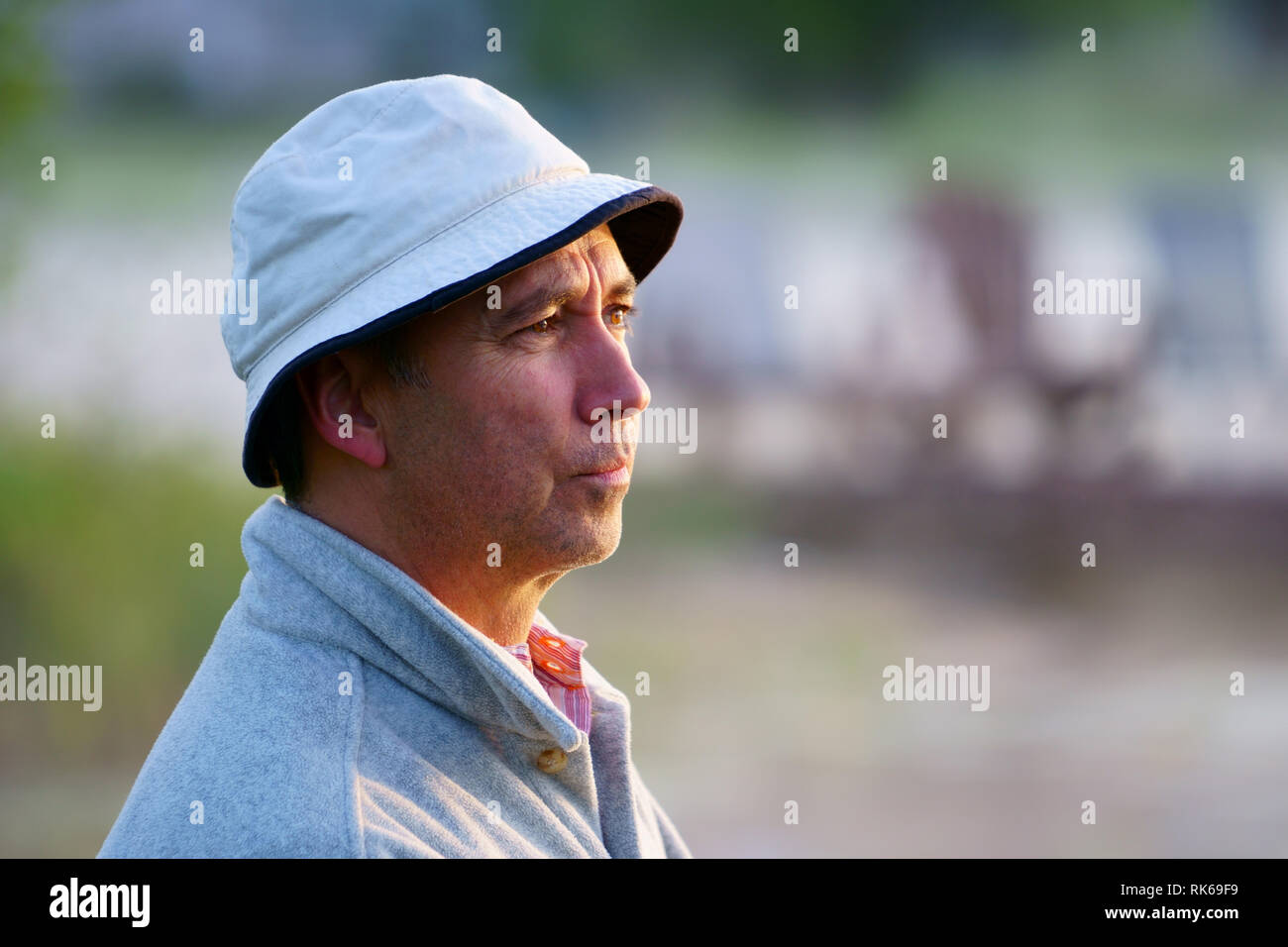Portrait, portrait d'un pêcheur de race blanche, 50 ans, au bord du lac avec brouillard, tôt le matin juste avant le lever du soleil. Banque D'Images