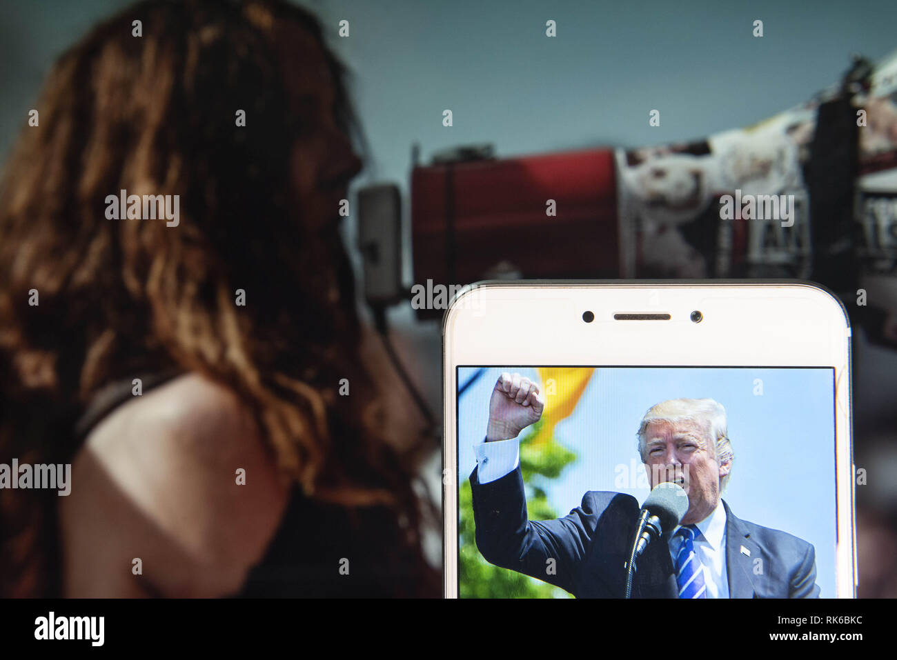 Hong Kong. Feb 8, 2019. Une image de l'United States 45e président Donald John Trump est vu sur un appareil mobile Android avec un manifestant à l'aide d'un mégaphone à l'arrière-plan. Credit : Miguel Candela/SOPA Images/ZUMA/Alamy Fil Live News Banque D'Images