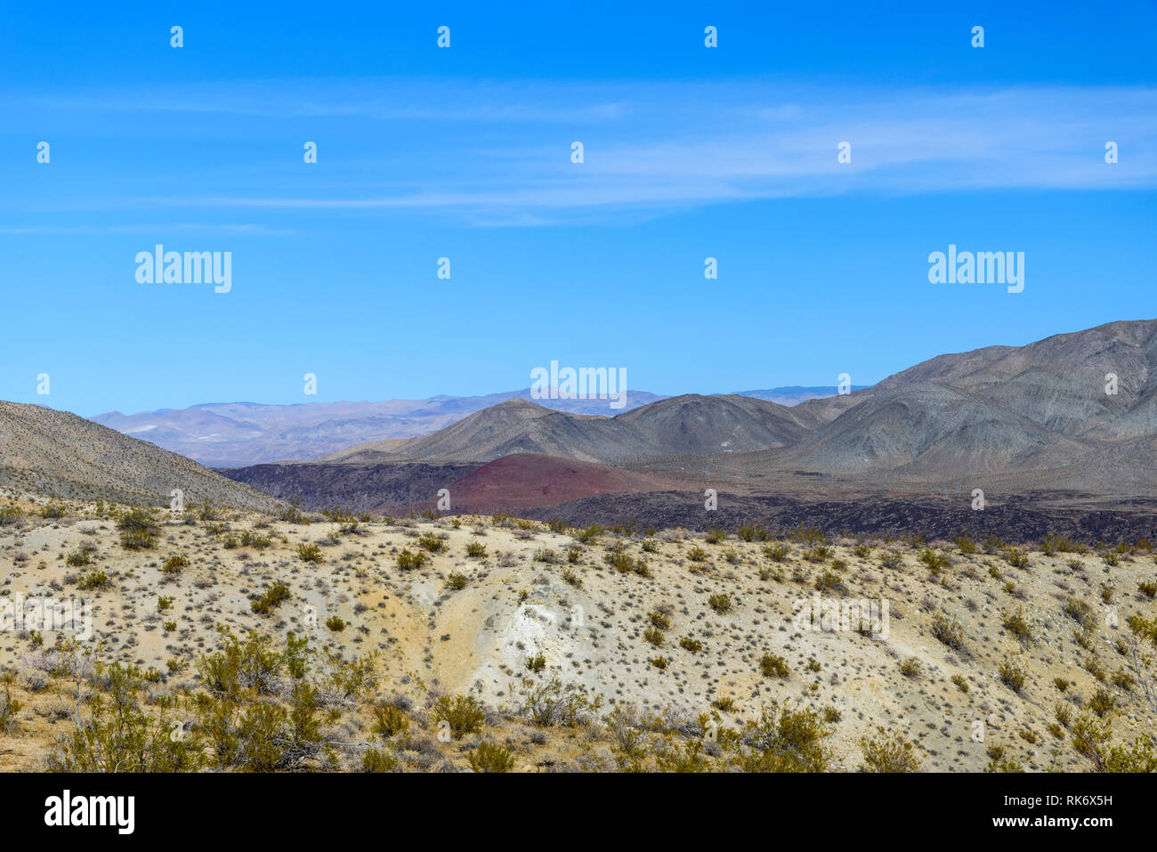 Le caribou des montagnes du désert chaud et sec, rouge et noir hills sous ciel bleu. Peu de végétation. Banque D'Images