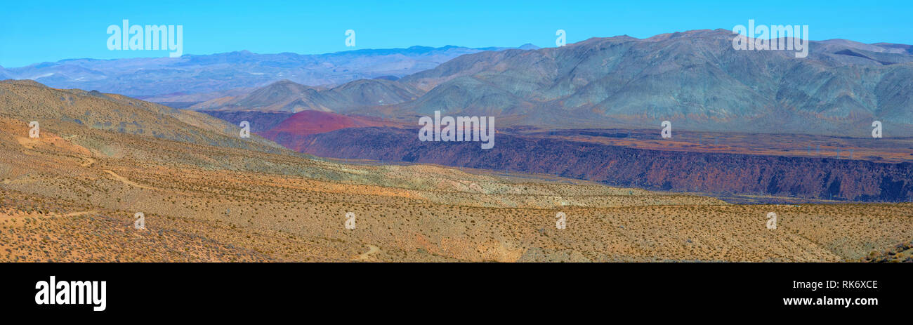 Vue panoramique du désert coloré avec orange jaune et rouge des montagnes, une gorge et du plateau sous ciel bleu. Banque D'Images