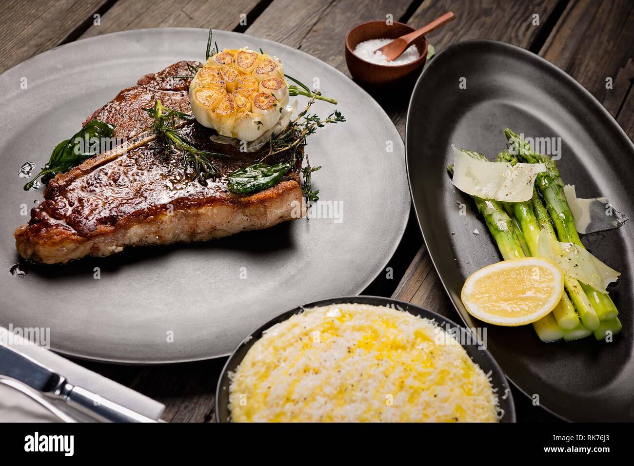 Steak de bœuf en T non coupé juteux servi avec des asperges et une purée de pommes de terre faite à la main. Banque D'Images