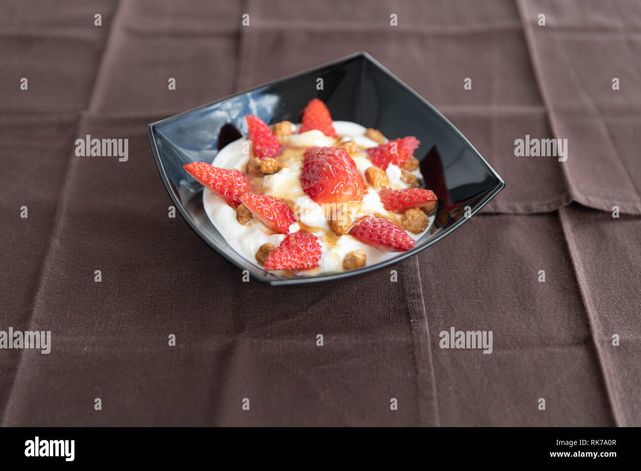 Délicieux yogourt avec fraises rouges frais et de miel sur le dessus Banque D'Images