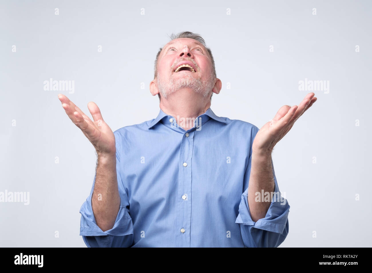 Happy senior man priant à Dieu avec ses mains posées jusqu'asling le ciel pour obtenir de l'aide Banque D'Images