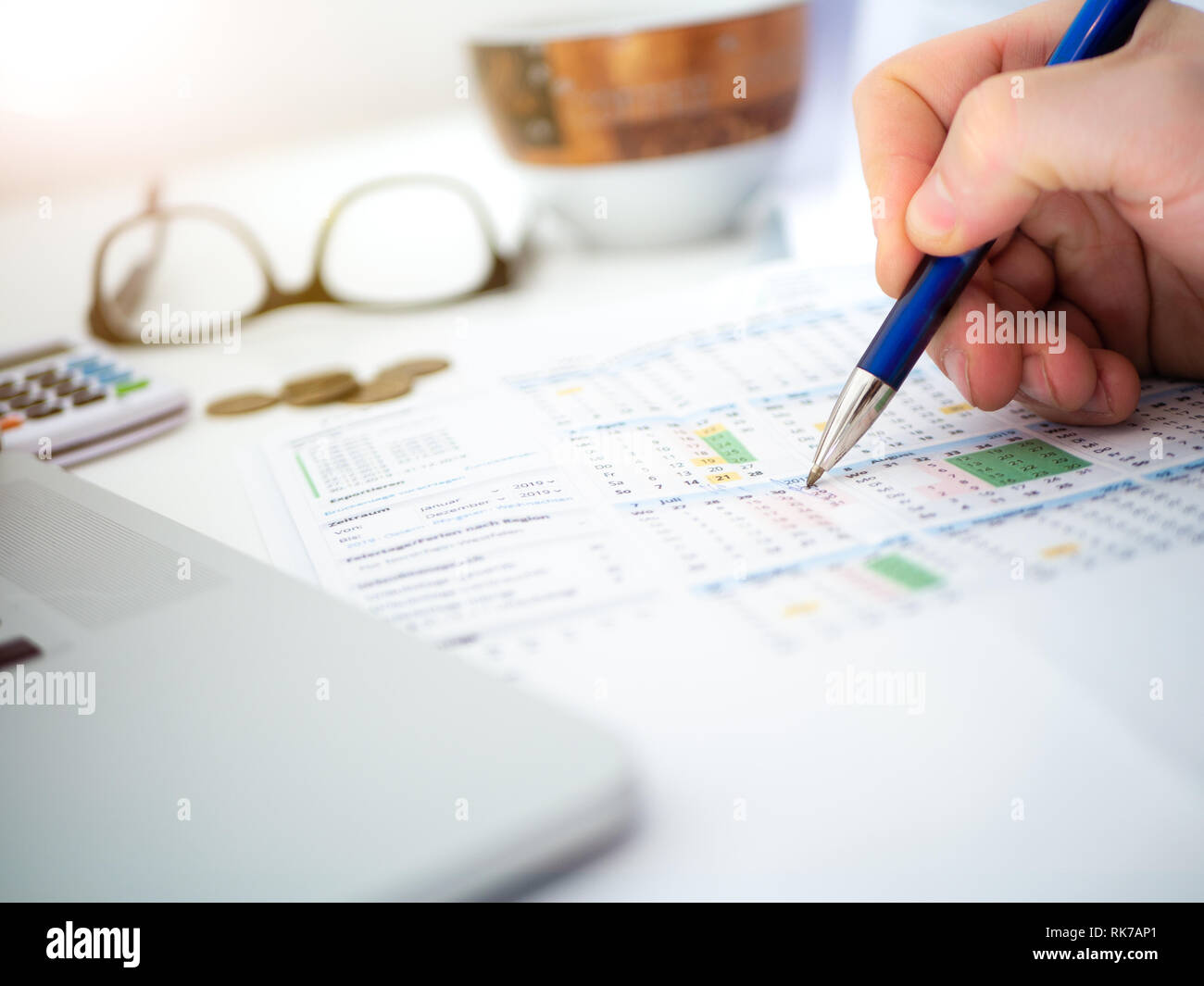 Close up of man's hand writing, schémas de planification et finances publiques avec des lunettes et tasse à café en arrière-plan Banque D'Images