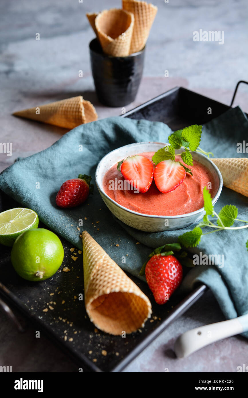 Sorbet à la fraise doux décoré de menthe et de cônes alvéolés Banque D'Images