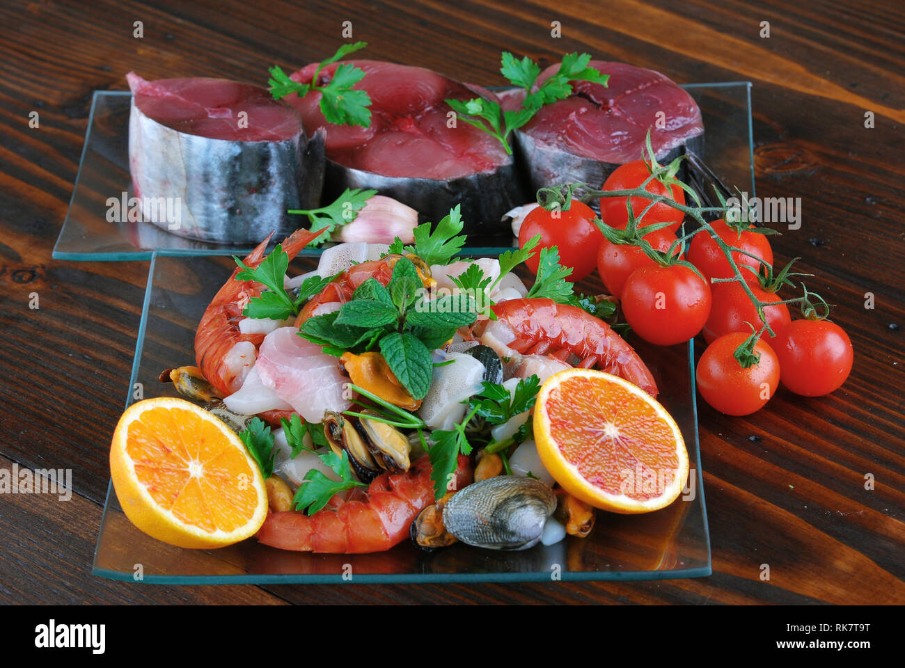 Plats en verre avec le poisson bonito mollusques et coquillages matières sur la planche de bois Banque D'Images