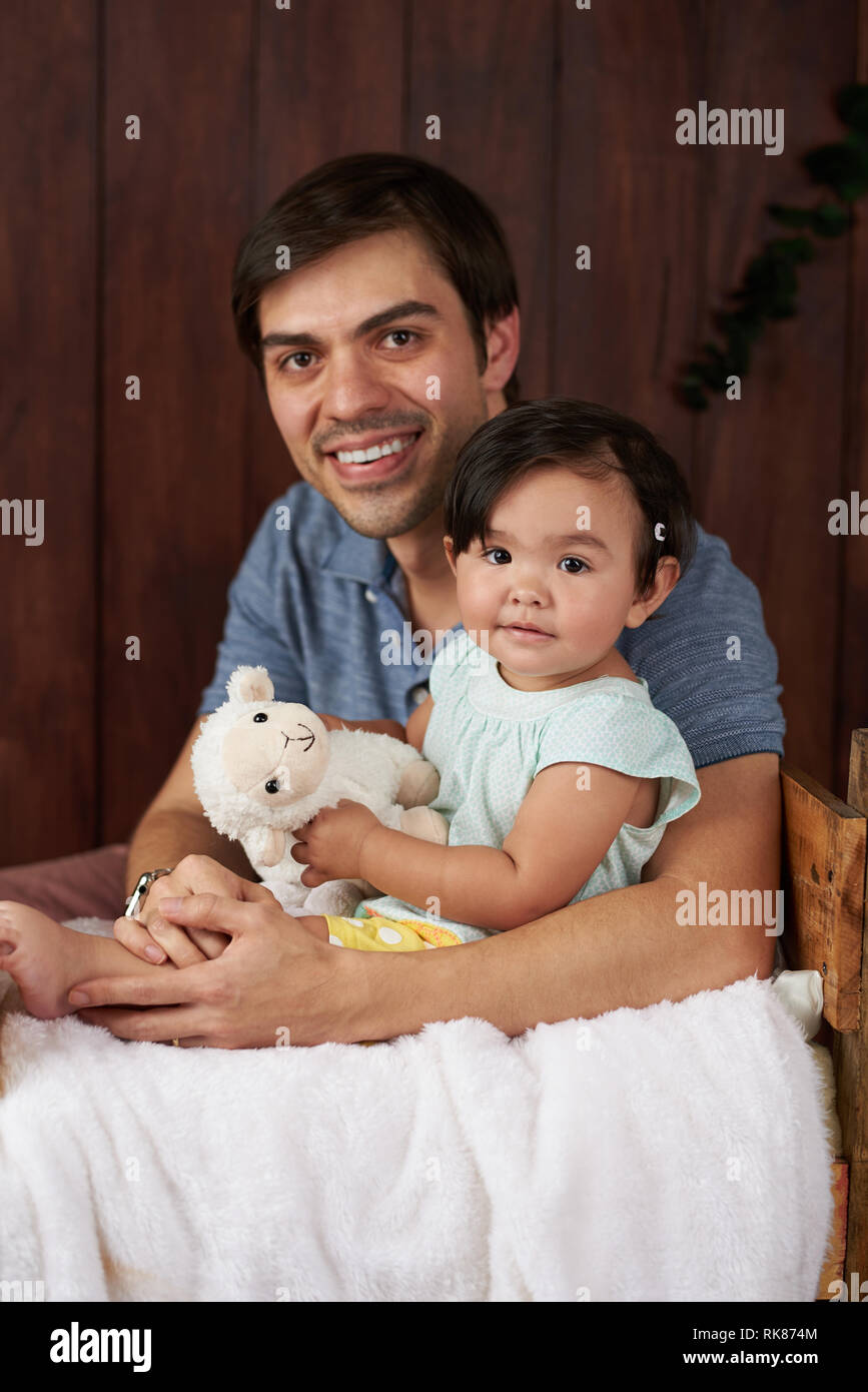 Smiling father and baby sur fond de studio en bois Banque D'Images